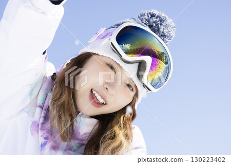 Cute woman enjoying snowboarding 130223402