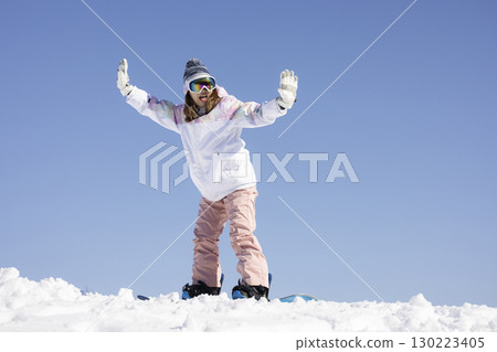 Cute woman enjoying snowboarding 130223405