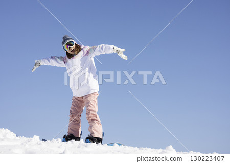 Cute woman enjoying snowboarding 130223407