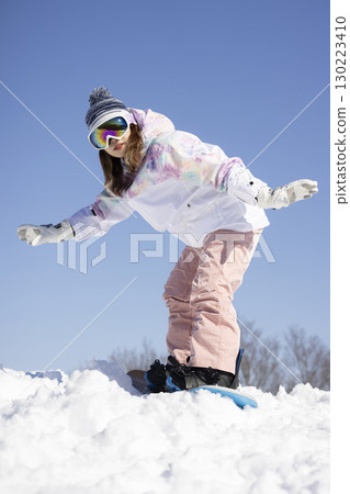 Cute woman enjoying snowboarding Cute woman enjoying snowboarding 130223410