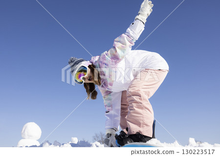 Cute woman enjoying snowboarding 130223517