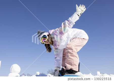 Cute woman enjoying snowboarding Cute woman enjoying snowboarding 130223518