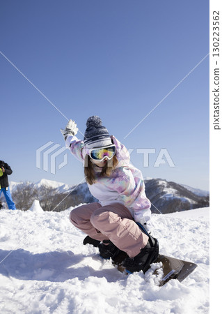 Cute woman enjoying snowboarding 130223562