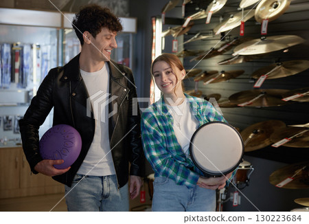 A man and woman hold a tambourine and purple ball in a store 130223684