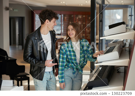 Young musicians creatively exploring various instruments in a modern studio setting 130223709