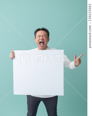 Middle aged businessman gripping blank white banner, gesturing aggressively and yelling with clenched eyes against vivid turquoise backdrop, revealing intense workplace stress 130225081