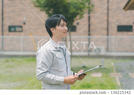 Contractors conducting outdoor surveys and inspections 130225342