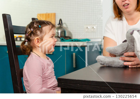 Loving mother helping daughter learn through play in kitchen. Concept of positive parenting, preschool skills, and child psychology 130225654