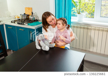 Smiling woman teaching toddler girl through creative play at table. Concept of early skills, Montessori principles, and child psychology. Top view 130225661