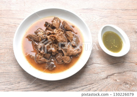 slice braised pork stew in herb brown soup dipping chili and sour sauce on plate 130226079