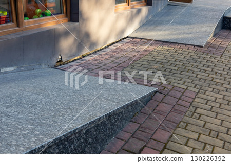 Textured paving and ramps improve accessibility outside stores, offering a smooth walk for all pedestrians and those with mobility needs 130226392