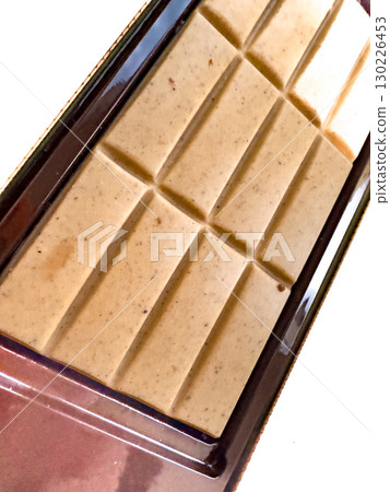Chipped white chocolate bar with additives 130226453