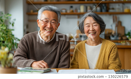 老年夫婦溫馨的日常 | 客廳/廚房裡夫妻倆笑容滿面，餐桌前查看文件的照片 130226579