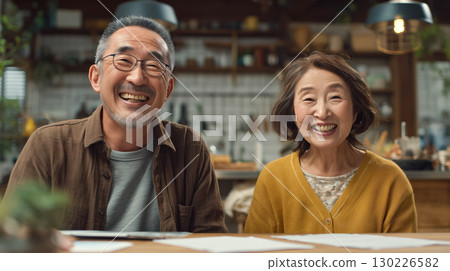 一對老年夫婦在咖啡館風格的房間裡微笑交談的典型場景 130226582