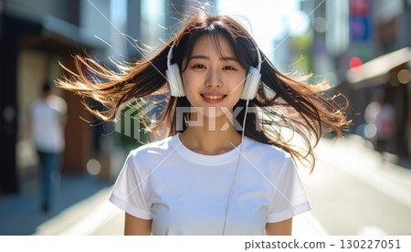 Lifestyle: Portrait of a young woman listening to music with headphones 130227051