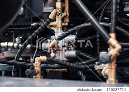 Close-up of hydraulic connectors and valves on industrial equipment. 130227724