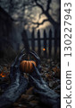 Black monsters scary hands with sharp nails grow out of the ground and clutching a pumpkin, outdoor next to old buildings in autumn. 130227943