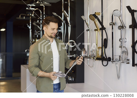 Man Choosing Shower Faucet in Plumbing Store Man Choosing Shower Faucet in Plumbing Store 130228008