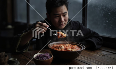 Chef enjoying delicious hot kimchi stew in restaurant by window on rainy day Chef enjoying delicious hot kimchi stew in restaurant by window on rainy day 130228361