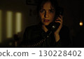 Young woman making a dramatic phone call in a dark room 130228402
