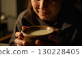 Woman enjoying warm milk or cream soup in wooden bowl 130228405