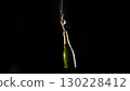 Champagne bottle uncorking with cork popping out on black background 130228412