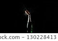 Champagne bottle popping with cork and bubbles on black background 130228413