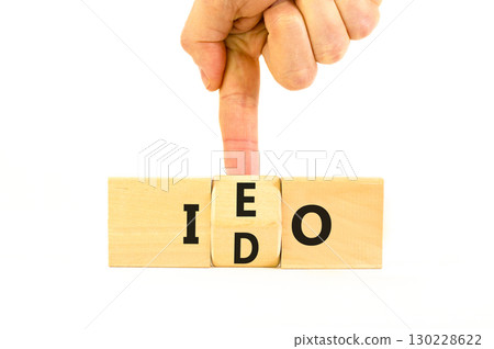 Initial exchange or DEX offering symbol. Concept words abbreviation IEO or IDO on wooden block. Beautiful white table white background. Business Initial exchange or DEX offering concept. Copy space. 130228622