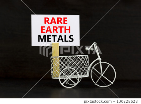 Rare earth metals symbol. Concept words Rare earth metals on beautiful white paper on wooden clothespin. Beautiful black background. Business and rare earth metals concept. Copy space. 130228628