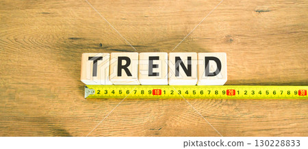 Trend and trending symbol. Concept word Trend on beautiful wooden blocks. Beautiful wooden table wooden background. Beautiful yellow ruler. Business lifestyle trend and trending concept. Copy space. Trend and trending symbol. Concept word Trend on beautiful wooden blocks. Beautiful wooden table wooden background. Beautiful yellow ruler. Business lifestyle trend and trending concept. Copy space. 130228833