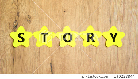 Story symbol. Concept word Story on beautiful yellow paper stars. Beautiful wooden table wooden background. Business lifestyle story concept. Copy space. 130228844