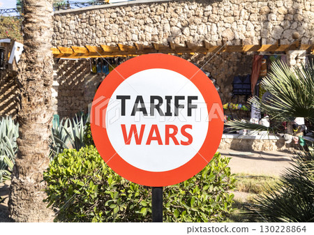 Trade tariff wars symbol. Concept word Tariff wars on beautiful red and white road sign. Beautiful palm tree and market background. Business trade tariff wars concept concept. Copy space. 130228864