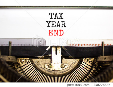 Tax year end symbol. Concept words Tax year end typed on beautiful old retro vintage typewriter. Beautiful white background. Business tax year end concept. Copy space. Tax year end symbol. Concept words Tax year end typed on beautiful old retro vintage typewriter. Beautiful white background. Business tax year end concept. Copy space. 130228886