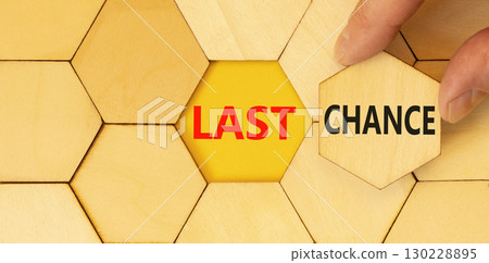 Last chance symbol. Concept word Last chance on beautiful wooden puzzles. Businessman's hand. Beautiful yellow paper background. Business last chance concept. Copy space. Last chance symbol. Concept word Last chance on beautiful wooden puzzles. Businessman's hand. Beautiful yellow paper background. Business last chance concept. Copy space. 130228895