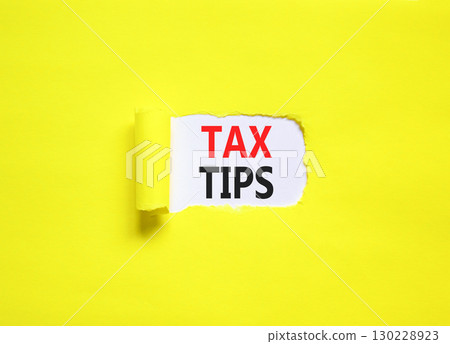Tax tips symbol. Concept word Tax tips on beautiful white paper. Beautiful yellow paper background. Business tax tips concept. Copy space. 130228923