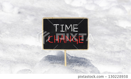 Time change symbol. Concept word Time change on beautiful black blackboard. Beautiful white snow background. White snow. Black blackboard. Business time change concept. Copy space. 130228938