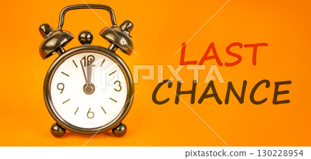 Last chance symbol. Concept word Last chance on beautiful orange paper. Beautiful black alarm clock. Beautiful orange paper background. Business last chance concept. Copy space. Last chance symbol. Concept word Last chance on beautiful orange paper. Beautiful black alarm clock. Beautiful orange paper background. Business last chance concept. Copy space. 130228954