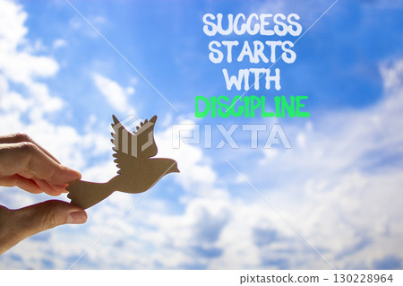 Success starts with discipline symbol. Concept words Success starts with discipline. Beautiful blue sky and clouds background. Business success starts with discipline concept. Copy space Success starts with discipline symbol. Concept words Success starts with discipline. Beautiful blue sky and clouds background. Business success starts with discipline concept. Copy space 130228964