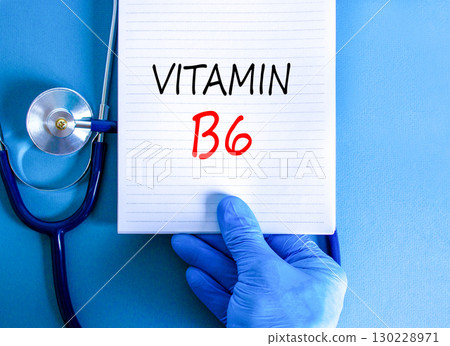 Vitamin B6 symbol. Concept words Vitamin B6 on beautiful white note. Doctor's hand in blue medical glove. Stethoscope. Beautiful blue background. Medical healthy lifestyle Vitamin B6 concept. Vitamin B6 symbol. Concept words Vitamin B6 on beautiful white note. Doctor's hand in blue medical glove. Stethoscope. Beautiful blue background. Medical healthy lifestyle Vitamin B6 concept. 130228971