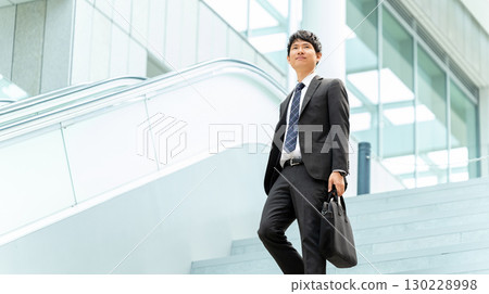 男商人在辦公區走下樓梯 130228998