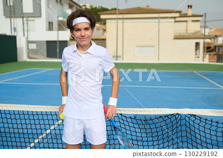 Teen Boy Holding Tennis Equipment Posing on Outdoor Tennis Court 130229192