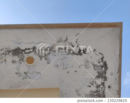 Close up of a weathered wall with peeling paint under a clear blue sky day Close up of a weathered wall with peeling paint under a clear blue sky day 130229620