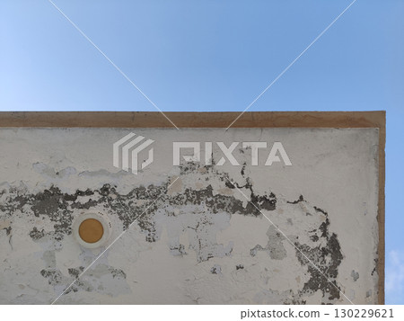 Corner of a weathered white building against a clear blue sky background view Corner of a weathered white building against a clear blue sky background view 130229621