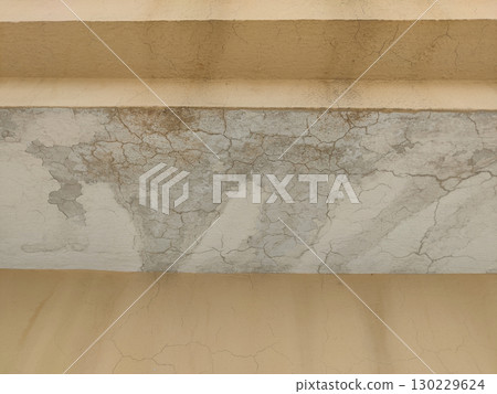 Close up of a cracked wall with peeling paint and a beige colored surface Close up of a cracked wall with peeling paint and a beige colored surface 130229624
