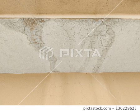 Close up of damaged ceiling with cracks and water stains on aged surface Close up of damaged ceiling with cracks and water stains on aged surface 130229625