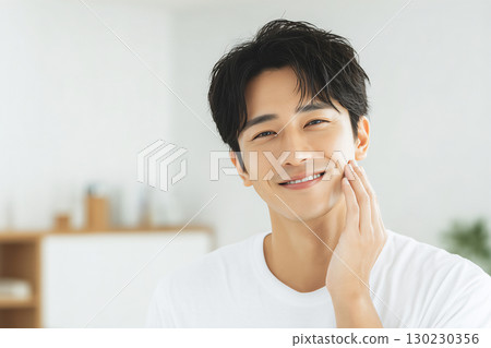 一位衣著整潔的日本年輕男子雙手摀著皮膚微笑 130230356