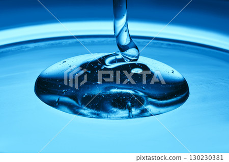 The texture of a cosmetic product in the form of jelly or gel on a blue background. The texture of a cosmetic product in the form of jelly or gel on a blue background. 130230381