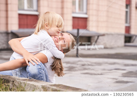 Caucasian female child hugging young adult woman outdoors on a sunny day Caucasian female child hugging young adult woman outdoors on a sunny day 130230565
