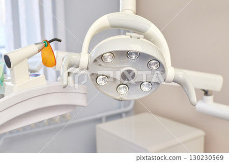 Modern dental equipment with led surgical light in a clean white dental office Modern dental equipment with led surgical light in a clean white dental office 130230569