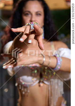 Close-Up of Woman's Hand with Decorative Jewelry in Vibrant Lighting 130230959